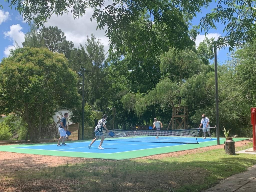 Compañeros disfrutando de un juego de pickleball durante la despedida de año en Rafaella ChacraEventos