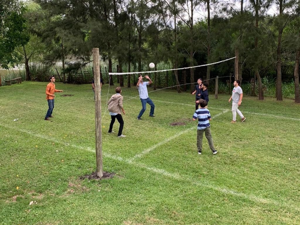 Compañeros disfrutando de un juego de volleyball en un día soleado durante la despedida de año en Rafaella ChacraEventos