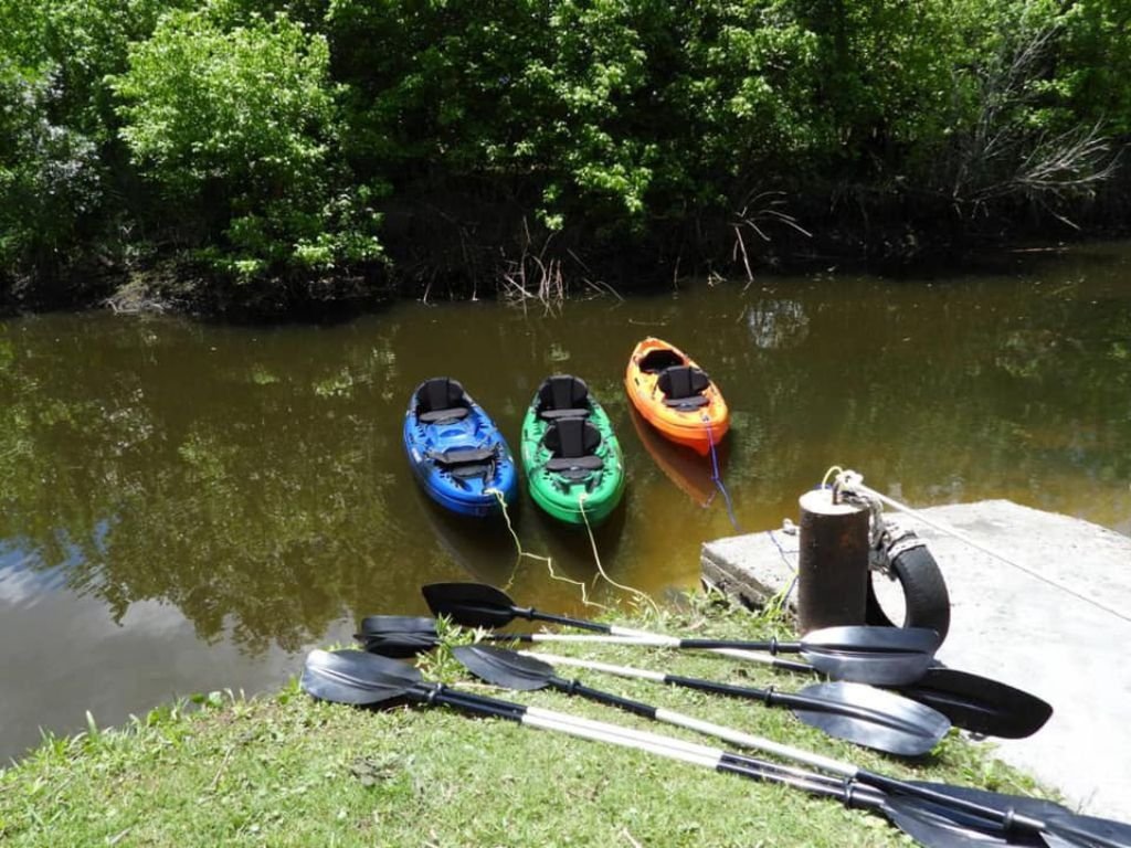 Kayaks estacionados a la orilla del arroyo de Las Brujas, listos para la aventura en Rafaella ChacraEventos