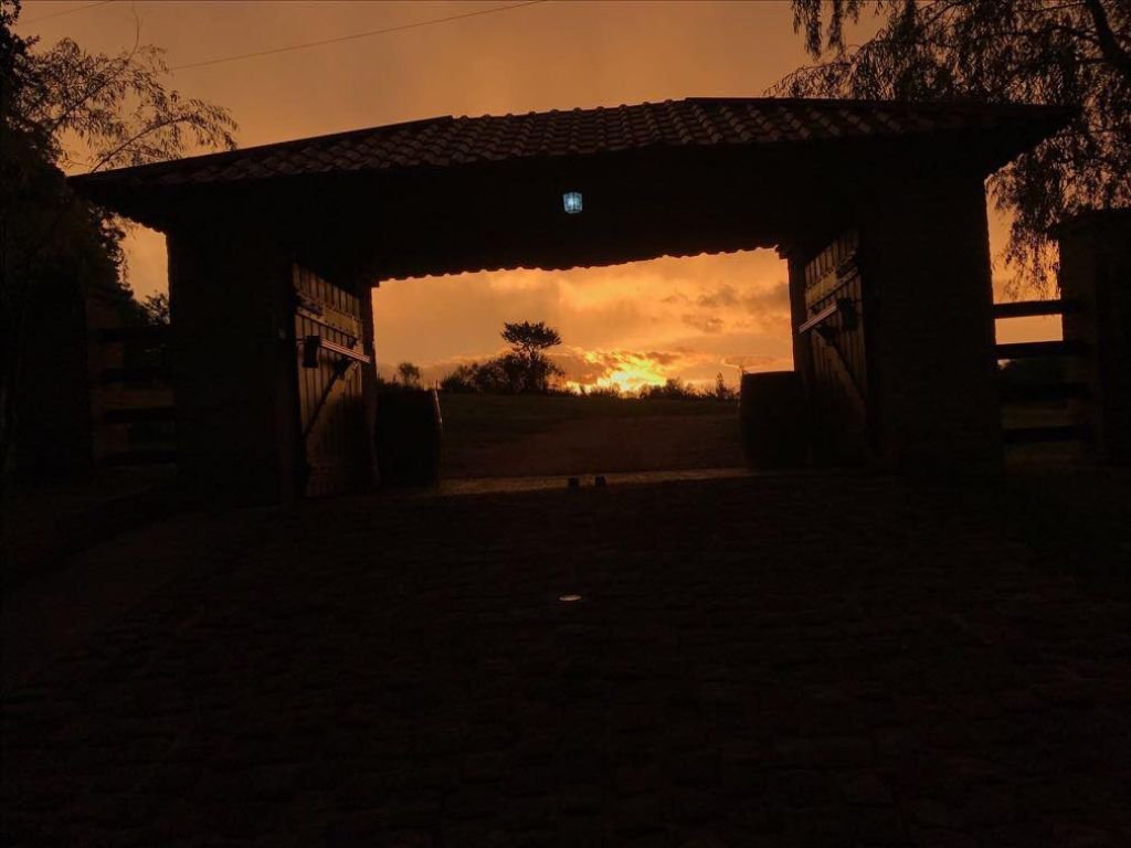 Elegante entrada a Rafaella ChacraEventos al atardecer, rodeada de un ambiente cálido y acogedor